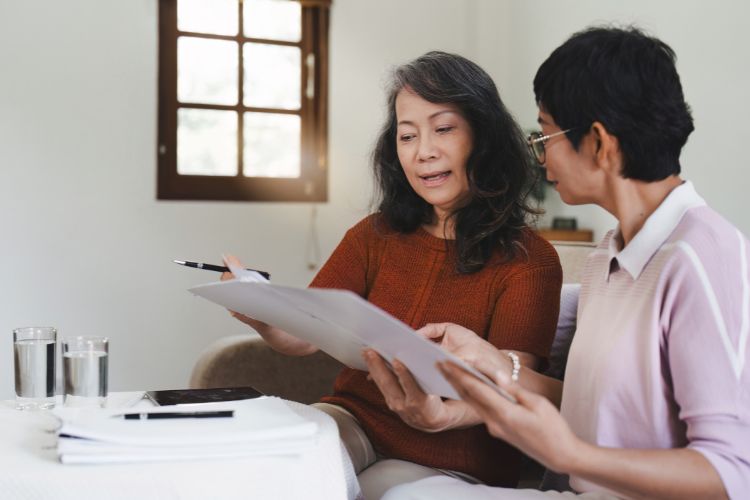 two women working on USCIS papers at home